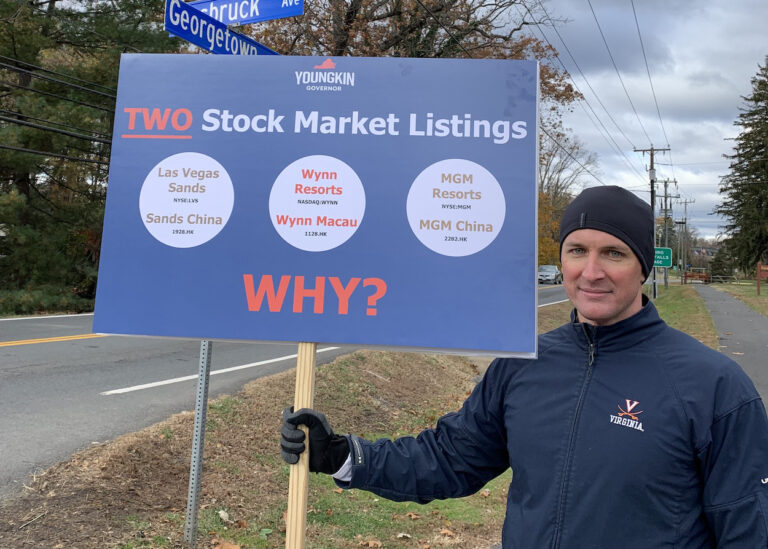 Why is a man standing outside the old Forestville schoolhouse with a sign?